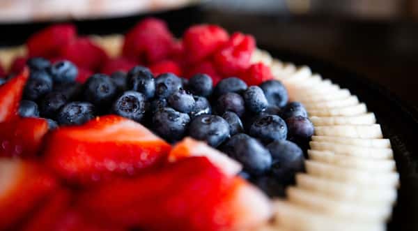close-up of fresh blueberries and strawberries arranged on a dessert tart