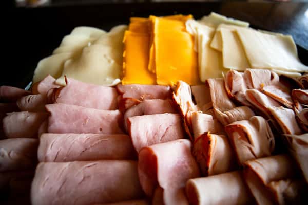 assorted deli meats and sliced cheeses arranged on a charcuterie platter