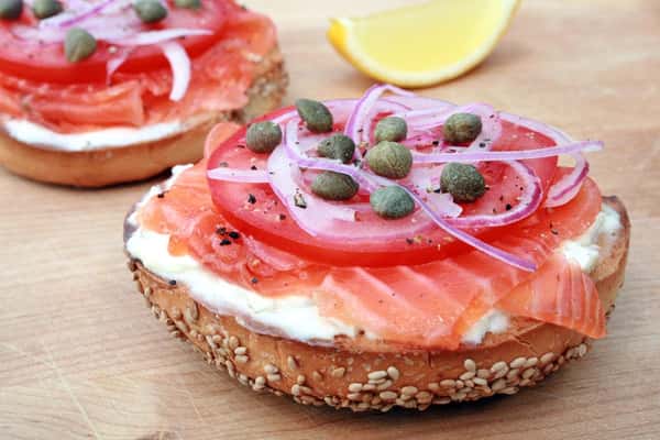 smoked salmon bagel with cream cheese, capers, red onion, and lemon wedge