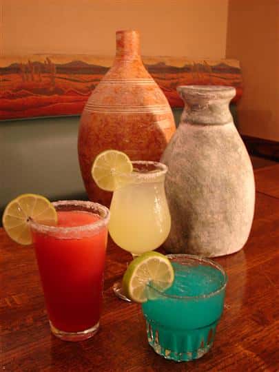 various mixed drinks displayed on a counter top