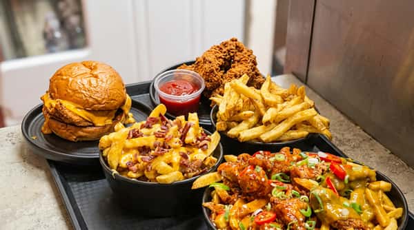 Tray of loaded fries, wraps, and chicken dishes