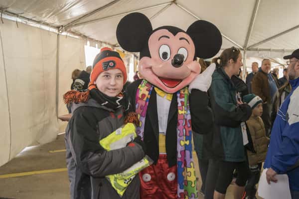 mickey mouse mascot posing with child contestant