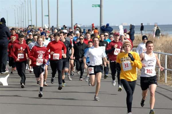 Marathon runners alongside the shore