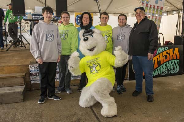 a mascot in a polar berar suit posing with rac runners
