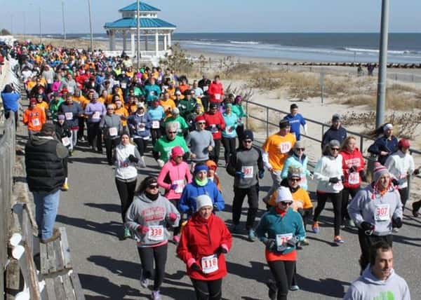 People running a marathon alongside the shore