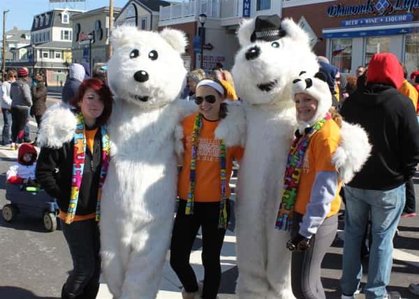 People taking a photo with people in polar bear costumes