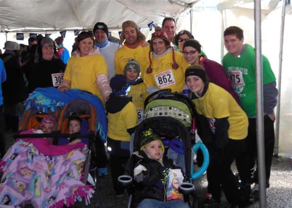 People taking a group photo with babies in strollers