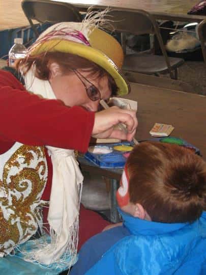 Lady face painting childs face