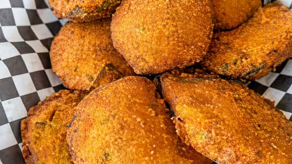 Fried chicken cutlets with a crispy, seasoned crust on checkerboard paper.
