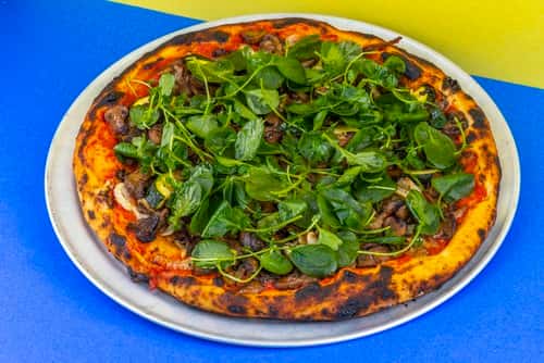 pizza topped with baby spinach
