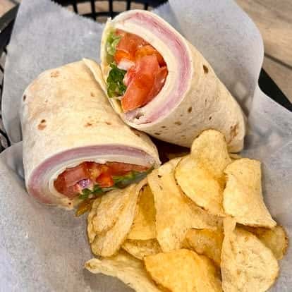 Turkey wrap sandwich with tomato and red onion, cut in half