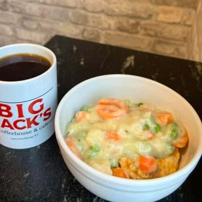 Bowl of chicken pot pie soup with a Big Jack's coffee mug