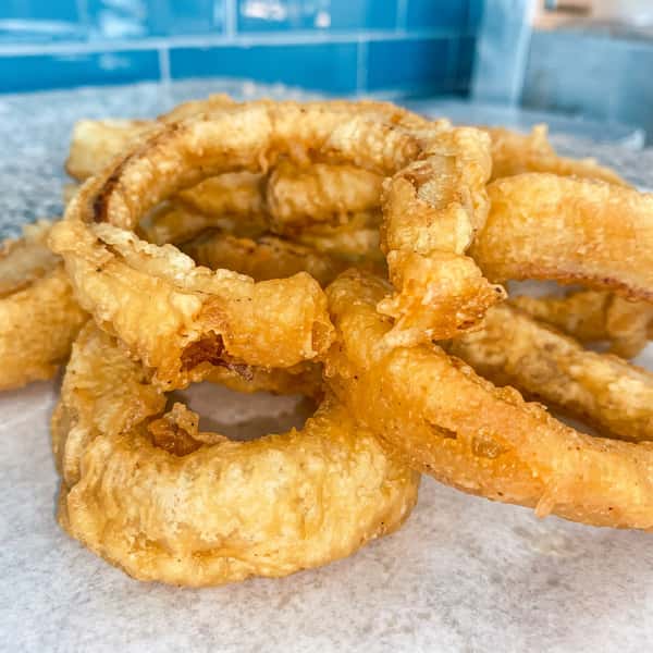 Crispy golden battered onion rings freshly prepared at a fish and chips restaurant