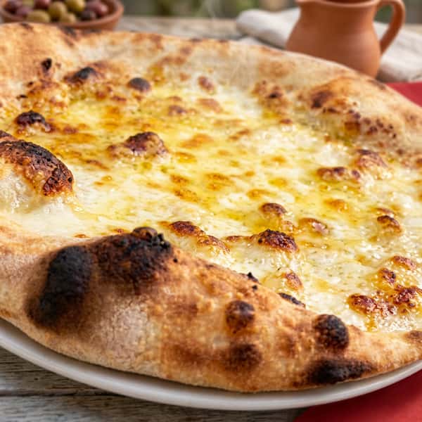 Wood-fired cheese pizza with melted golden cheese and a blistered, charred crust