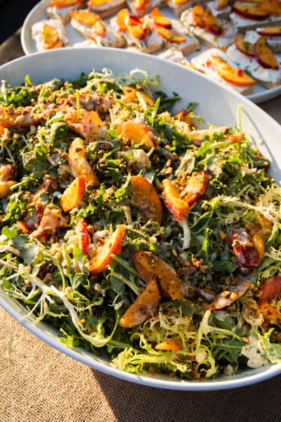 Peach salad served on a white platter. It's a close up shot that is big enough to share for a large event.