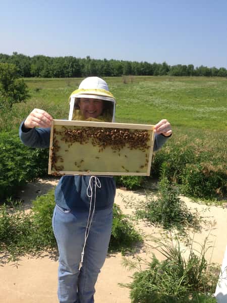 A female beekepper holds up honey bomb