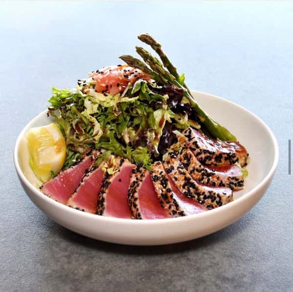 Mahi Tuna with fresh greens elegantly plated in a white dish