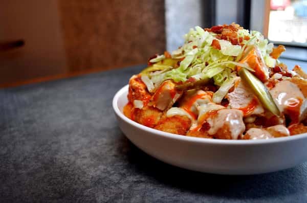 Vibrant red and green salad with a mix of proteins and vegetables drizzled in a red and white sauce