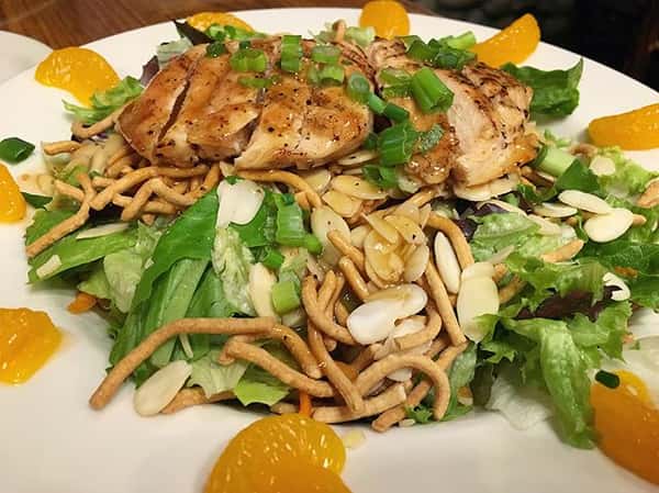 Oriental grilled chicken salad with tangarine slices in a bowl