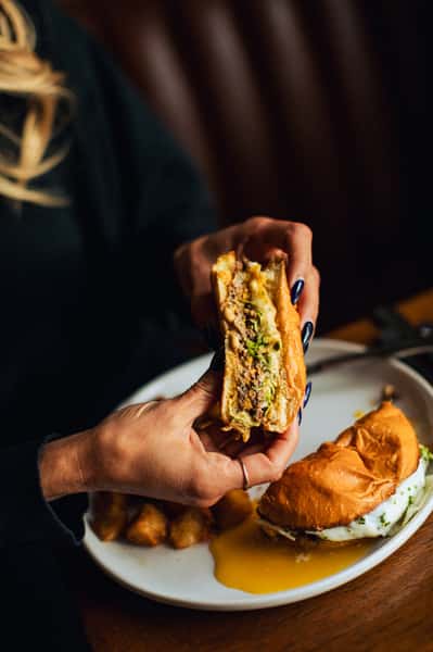 Woman's hands holding a half of a burger