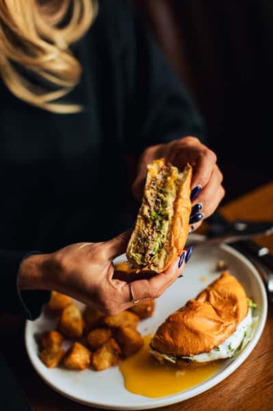 Woman's hands holding half of a burger