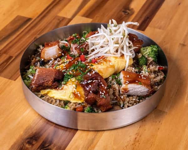 Loaded fried rice topped with egg, vegetables, and shredded cheese.