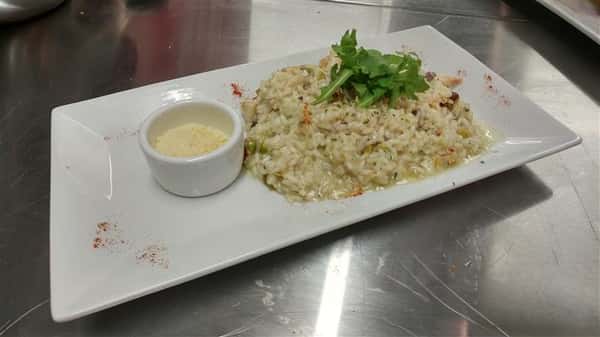 Mushroom, green peas, carrots, asparagus and arugula with arborio rice served with white sauce on the side