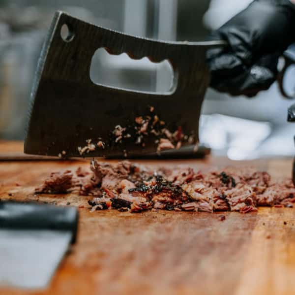 Large butcher knife slicing meat