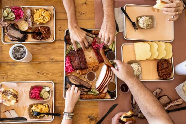Guests eating from multiple BBQ platters