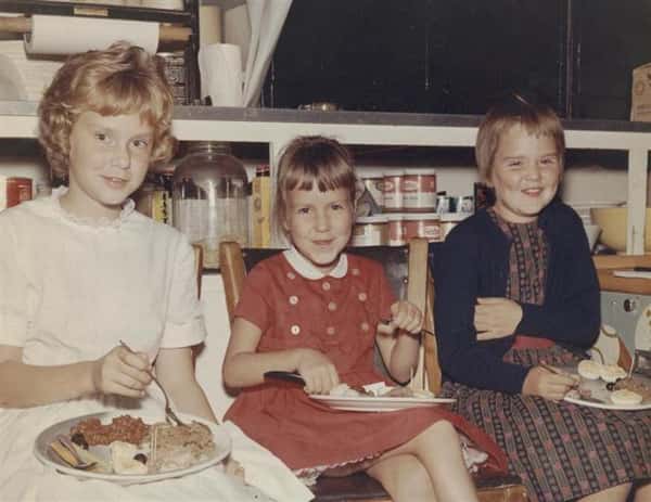 Vintage photo of three children smiling and enjoying a holiday dinner
