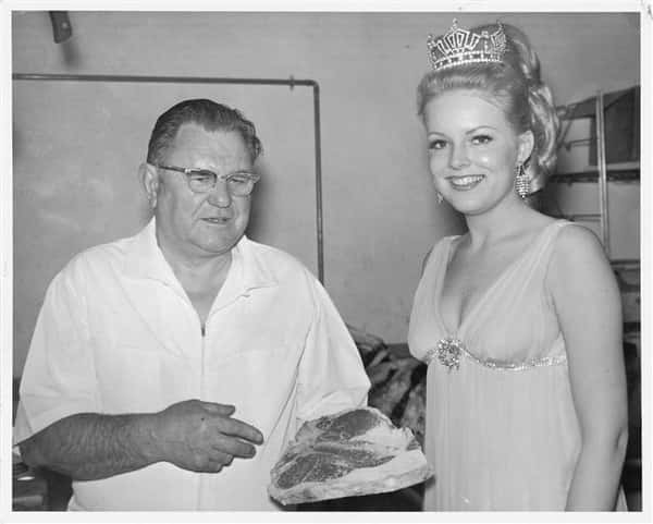 Vintage photo of Archie talking to pageant winner wearing her crown.