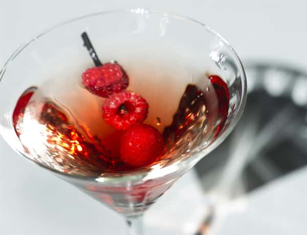 martini with raspberries as a garnish