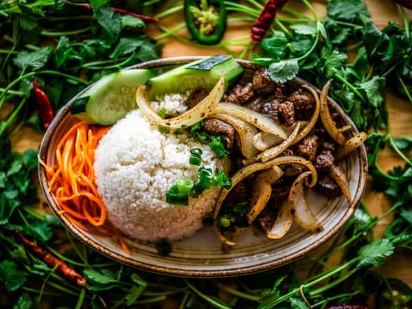 A mixed Vietnamese meal surrounded by decorative garnish on the table