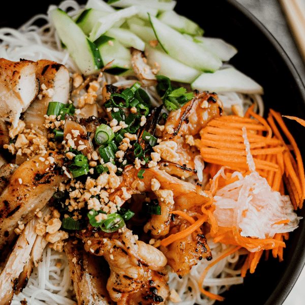 Close up of mixed Vietnamese meal with carrot slices, onions, and seasoning