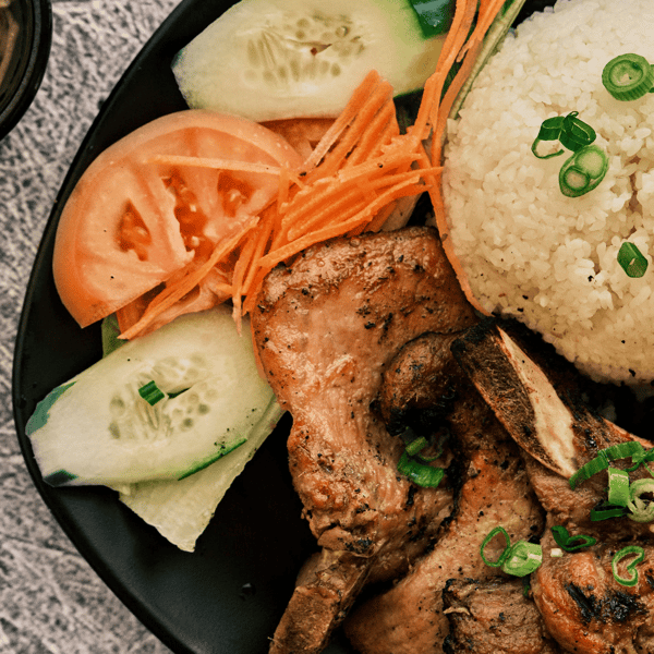 Close up of mixed Vietnamese meal with carrot slices, onions, and seasoning
