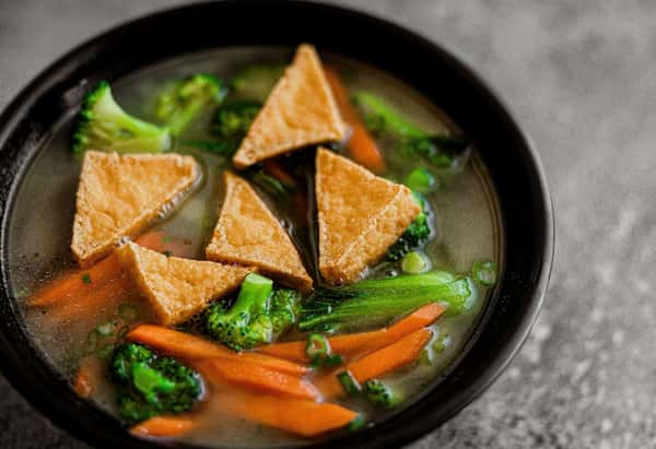 Triangular pieces of meat in a carrot and broccoli stew