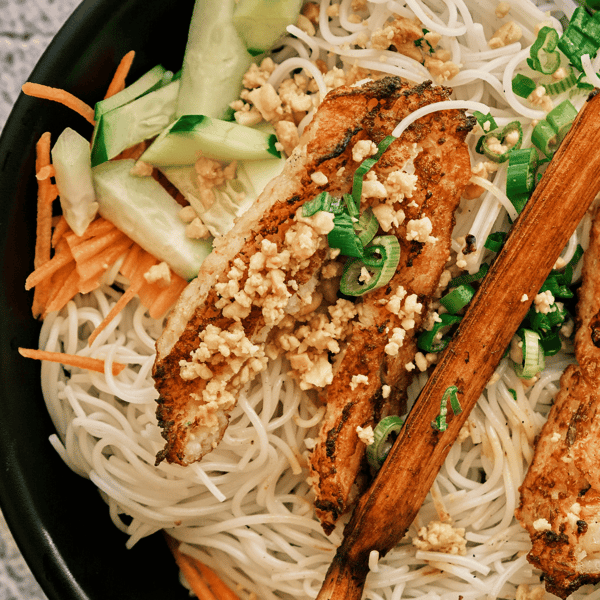 Close up of mixed Vietnamese meal with carrot slices, onions, and seasoning