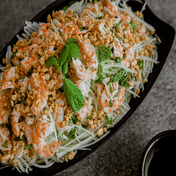 Close up of mixed Vietnamese meal with sliced onions and seasoning