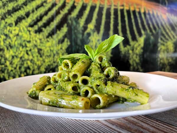 green pasta on a white plate