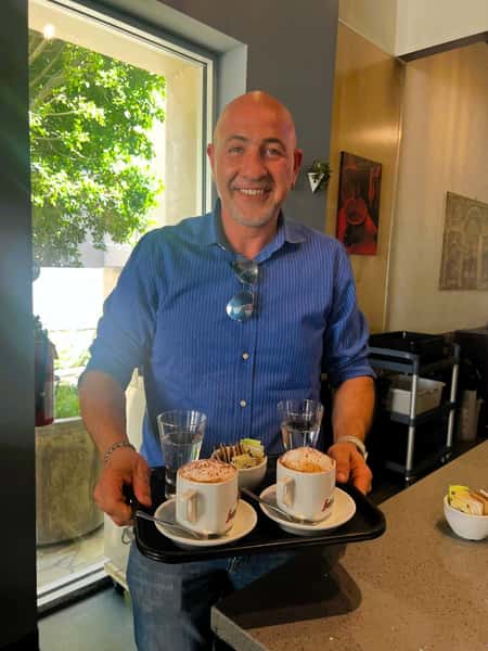 Chef Peter holding up two coffee drinks