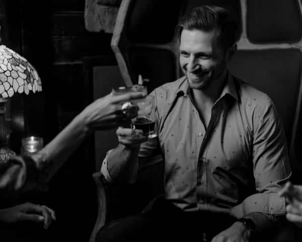 man and woman cheers with drinks