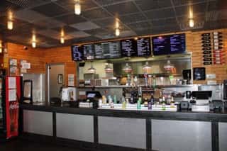 Interior view of Main Street Eats, showcasing the counter, menu boards, and beverage selection.