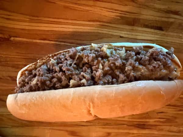 A steak sandwich on a wooden surface, ready to be served at Main Street Eats.