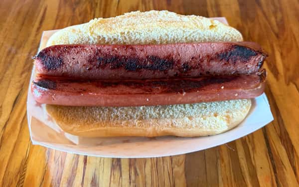 A grilled hot dog sits in a bun, ready to be served at Main Street Eats.