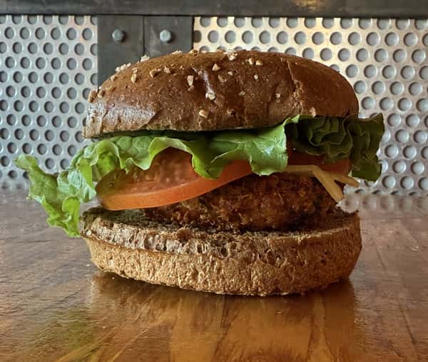 A veggie burger sits on a dark wood surface at Main Street Eats