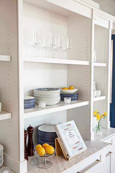 Shelves with stacked plates, bowls, wine glasses and decorations
