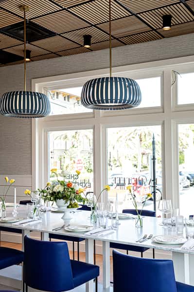 Dining table setup with flower vases, plates, glassware and silverware