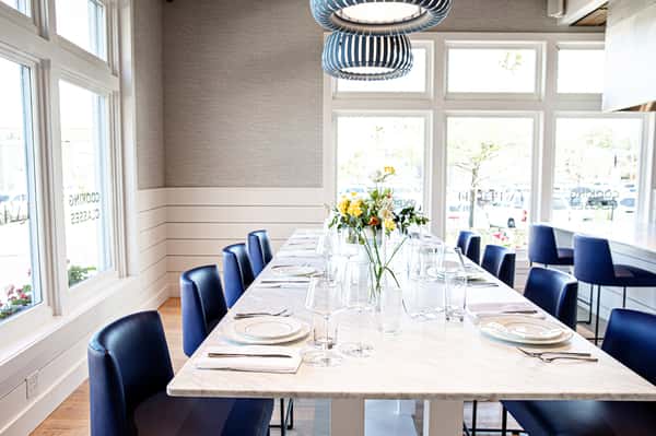 Dining table with flower vases, plates, glassware and silverware