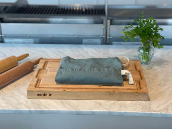Wooden cutting board with a folded apron on top