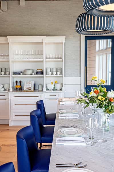 Dining table with flower vases, plates, glassware and silverware